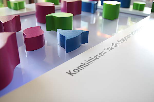 Spielsteine in blau, pink und grün auf einer Oberfläche